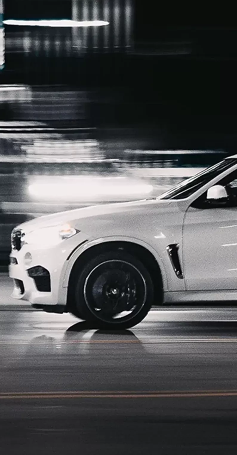 White 4x4 BMW driving in long exposure background