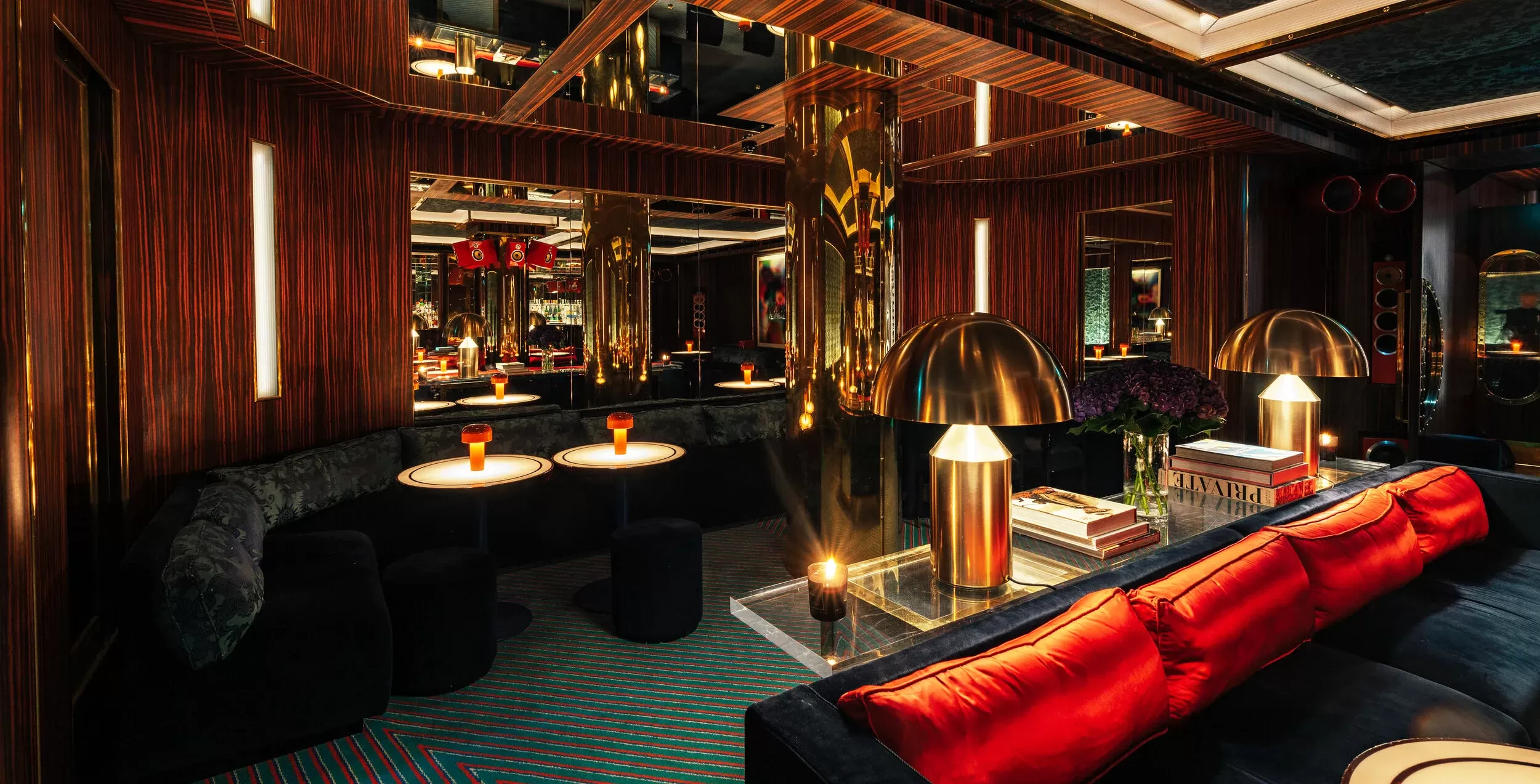 Fancy elevated living room-style interior with carpeted floors, navy velvet sofas and mirror-topped tables interior at The Dragon Room at Isabel, Mayfair, London