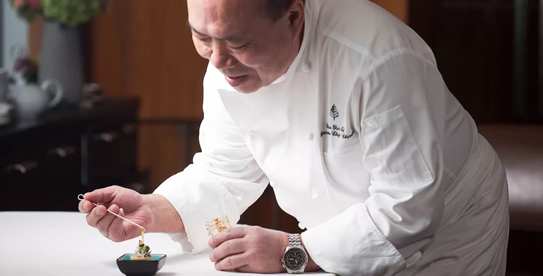 Chef Chan Yan-tak in chefs uniform preparing food