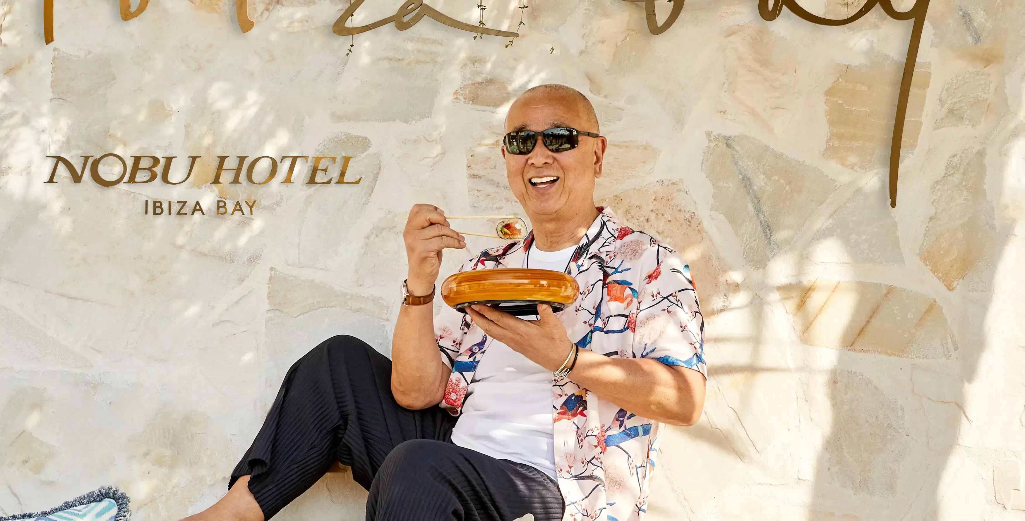 World-renowned chef Nobu Matsuhisa eating food sat outside of Nobu hotel Ibiza Bay, Ibiza