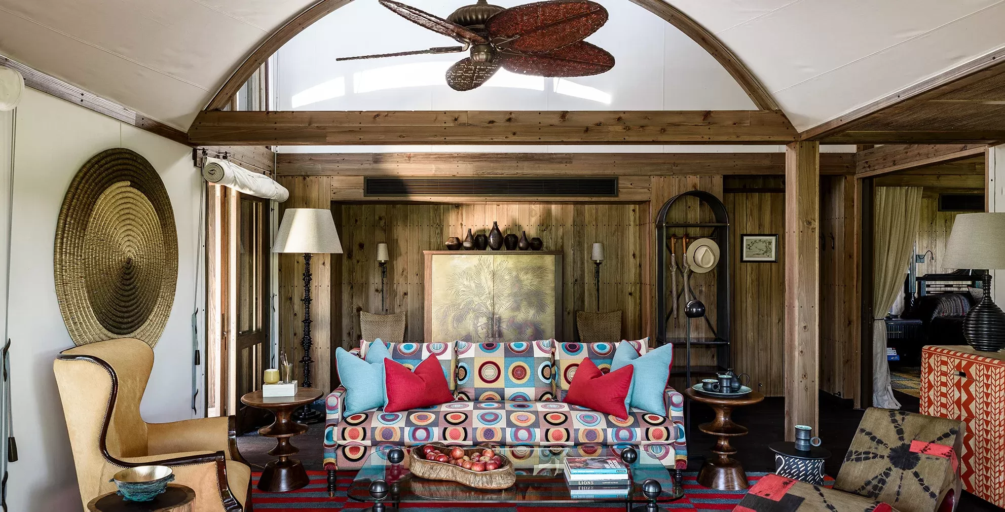 Rustic contemporary living room with gold and wooden sculptures and a multicolored circle printed sofa